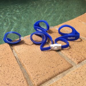 blue eyeline scoot kids swim googles laying on tiles next to a pool